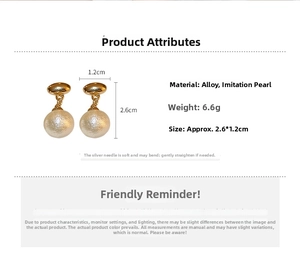 Detail view of gold drop earrings with white cotton pearls showing 2.6x1.2cm dimensions