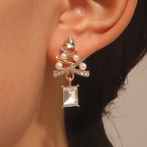 Close-up of sparkling Christmas tree earring with pearls and cubic zirconia on model ear