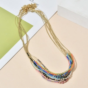 Vue détaillée du collier de perles multicouches colorées avec chaînes dorées fines