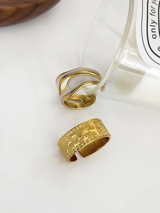 Detail of 18K gold pleated hollow ring and wide hammered band with marble inlay details