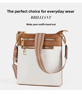 Detail of contrast PU leather crossbody bag with jacquard strap and gold zippers