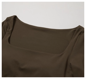Détail de l'encolure carrée sur un haut de yoga à manches longues marron foncé et coutures