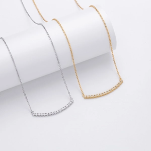 Gros plan de colliers en argent et or avec pendentifs sourires en oxydes de zirconium