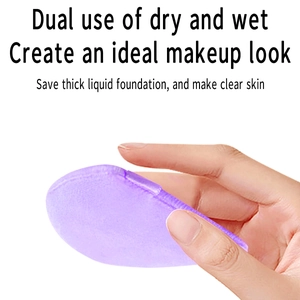 Detail of a purple dual-use makeup sponge held by hand for wet and dry application