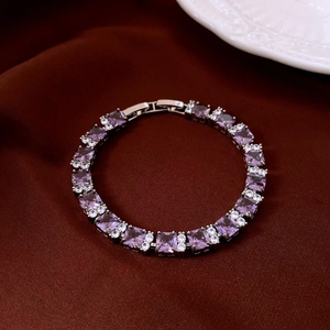Detailed close-up of oval purple zircon bracelet with silver clasp on red velvet