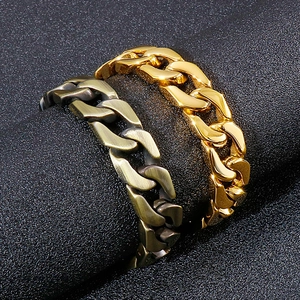 Men's chunky stainless steel Cuban link bracelet in gold and bronze finish on dark stone