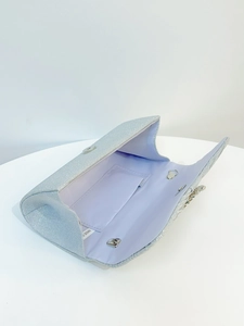 Detail view of silver glitter evening clutch showing light blue lining and inner pocket