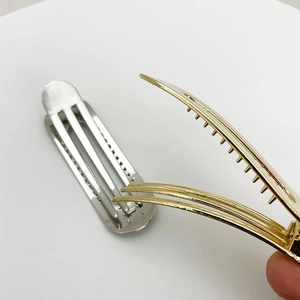 Close-up of gold and silver alloy hair clips showing internal mechanism and metallic gloss