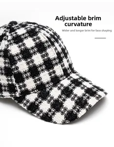 Close-up of black and white tweed baseball cap with adjustable foldable brim and textures
