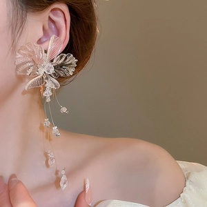Close-up of clear acrylic flower earrings with cascading crystal bead tassels on model