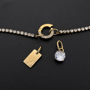 Dettaglio catena tennis placcata oro 14K con ciondolo Y e charms in strass