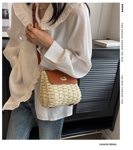 Detail of handmade straw crossbody bag with brown leather flap and golden rotary buckle