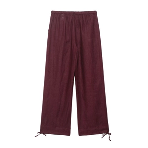 Detail of dark burgundy cotton linen wide-leg pants with elastic waist and bow tie cuffs