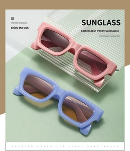 Detail of square thick-frame sunglasses in pink and blue with dark lenses