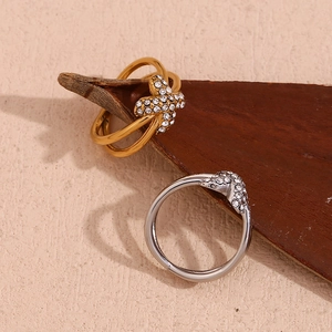 Detail eines 18K vergoldeten X-Rings mit Zirkonia-Mikropavé auf beige Hintergrund