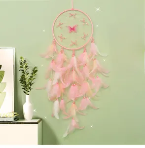 Detailed view of handmade pink dream catcher with soft feathers and butterfly charm
