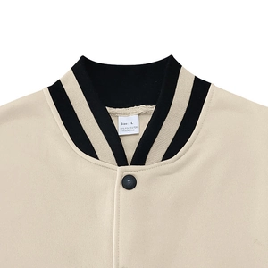 Detail of baseball collar jacket showing striped ribbing and matte metal buttons