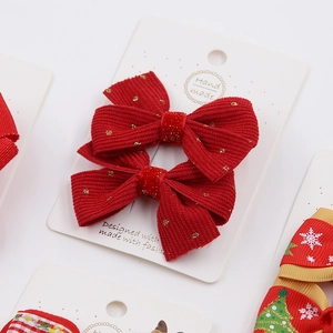 Detail of red corduroy Christmas bow hair clip with gold glitter on white card