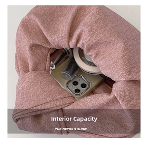 Macro view of the internal capacity of the pink fabric bag with phone and cosmetics
