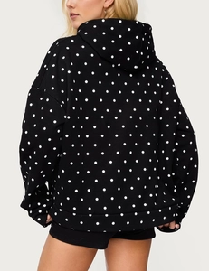 Back view of a black oversized hoodie with white polka dots and a cozy hood design