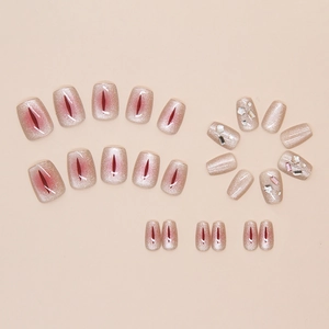 Macro detail of champagne cat-eye press-on nails with sparkling star and rhinestone accents