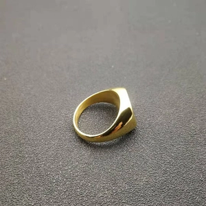 Detailed top view of a wide polished gold-plated stainless steel band ring with mirror finish