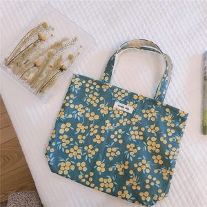 Detailed close-up of navy floral canvas tote bag with yellow berry pattern and simple wish label
