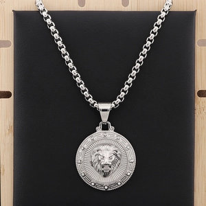 Macro shot of silver lion head pendant with crystal accents on a black leather display