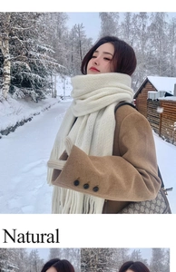 Close-up of cream white ribbed knit scarf with long fringe details in a winter setting