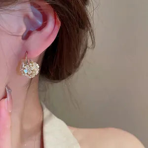 Boucles d'oreilles fleurs dorées avec pétales de perles portées pour un style chic