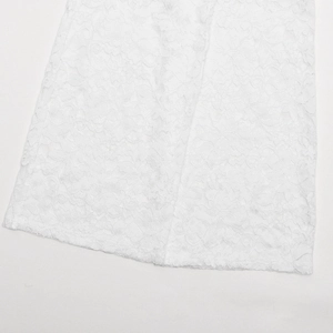 Gros plan sur la broderie en dentelle blanche complexe et la texture du tissu sur l'ourlet