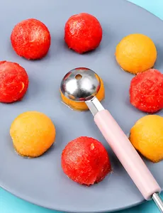 Macro detail of stainless steel fruit scooper with anti-stick holes and pink handle