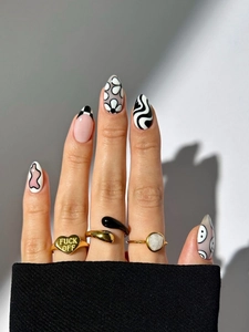 Detailed view of ornate gold rings and artistic nails with heart-shaped engraved band