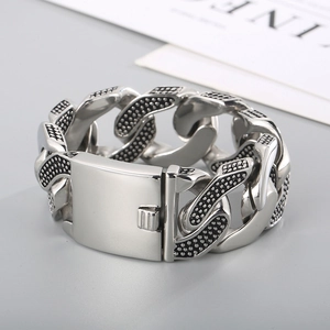 Dettaglio macro del bracciale maschile a catena spessa in acciaio con motivo a pois ossidati