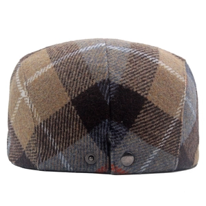Close-up of the back of a wool blend plaid beret showing metal snap buttons and tweed texture