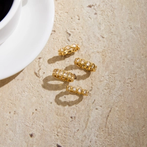 Detailed view of 18K gold plated eternity rings with sparkling zircons on stone surface