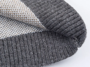 Macro detail of high-quality grey and beige jacquard knit texture with ribbed edges