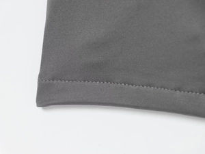 Detailed view of precision stitching and textured gray fabric on a stylish pleated dress