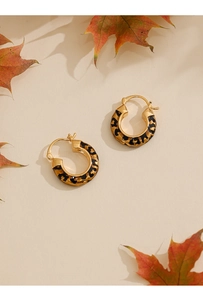 Detailed view of 14k gold-plated leopard print hoop earrings with maple leaf decor