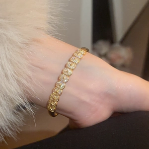 Detailed view of luxury gold-plated bangle with pavé-set round cubic zirconia crystals