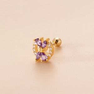 Detailed shot of golden screw back earring with purple pear-shaped gemstone and crystal bow