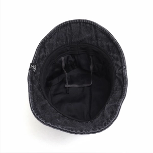 Detail view of black denim bucket hat interior featuring adjustable drawstrings and wash label