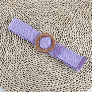 Detailed macro shot of a purple elastic woven belt with a round wood-grain buckle
