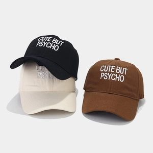 Three embroidered baseball caps in black, cream, and brown with 'Cute but Psycho' text