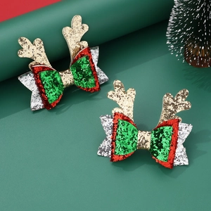 Detailed view of handmade Christmas antler bow hair clips with festive glitter material
