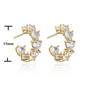 Detail of 17mm gold C-shaped hoop earrings with seven heart-shaped cubic zirconia stones