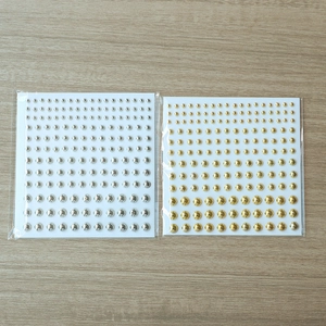 Detailed view of silver and gold round self-adhesive rivet stickers for hair and nail art