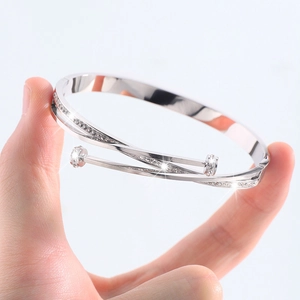 Detail view of silver Mobius nail bracelet with pavé cubic zirconia on grey background