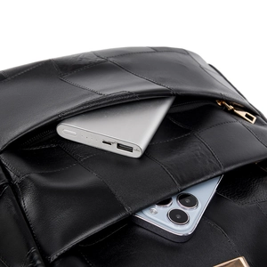 Detail shot of the black leather backpack interior showing power bank and phone storage