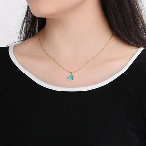 Close-up of elegant gold cat's eye stone necklace on neck with delicate lace design
